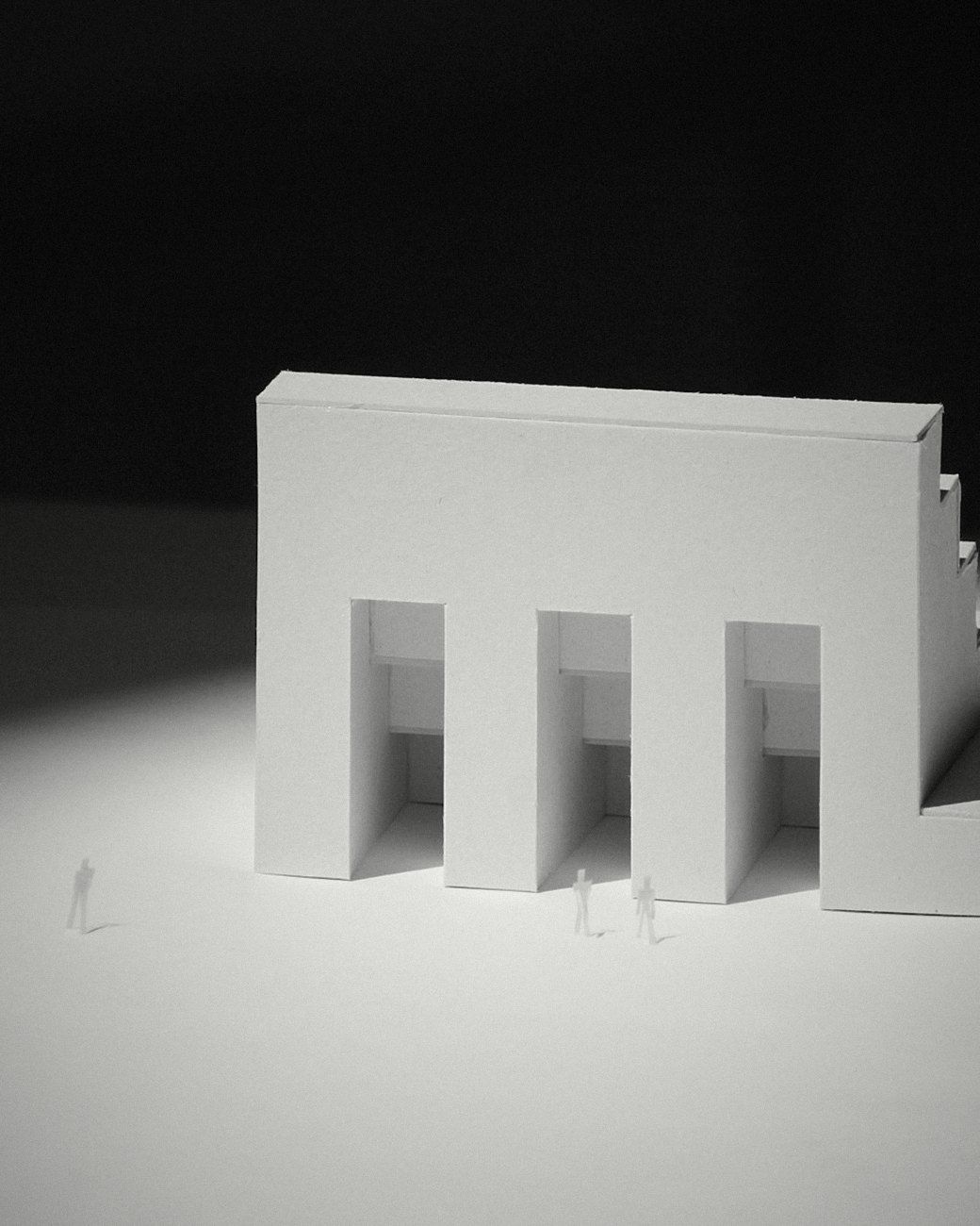 A white architectural model under a single light