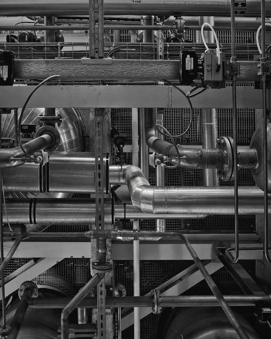 A dense network of industrial pipes, valves and gauges
