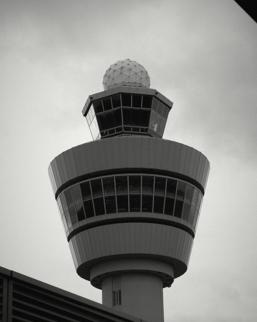 An airport control tower against a grey sky